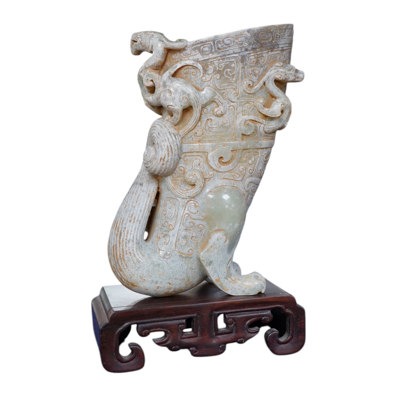 A large Chinese archaistic pale celadon and calcified jade rhyton, on a hardwood stand, 17.5cm high. Condition - fair to good.